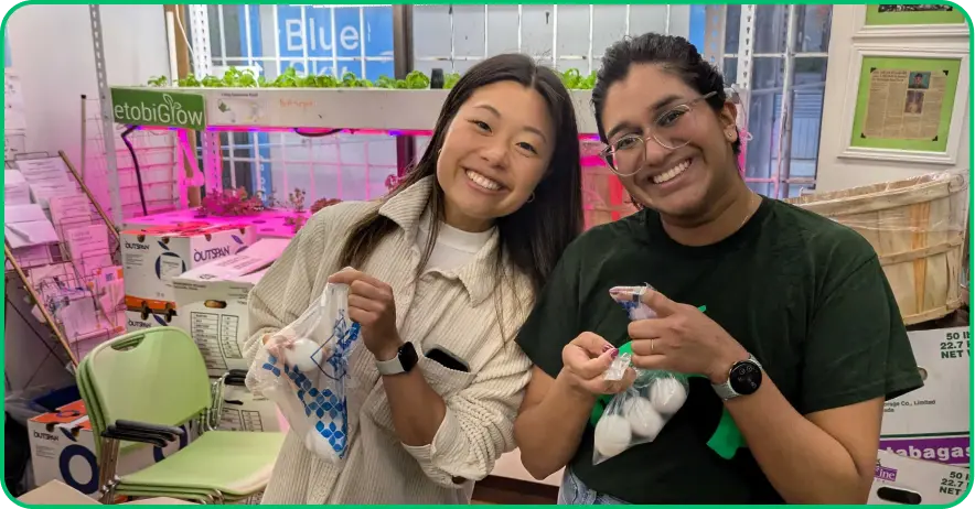 Two SurveyMonkey employees smiling and volunteering at a nonprofit