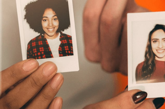 Hände, die zwei Headshots von verschiedenen Frauen halten 